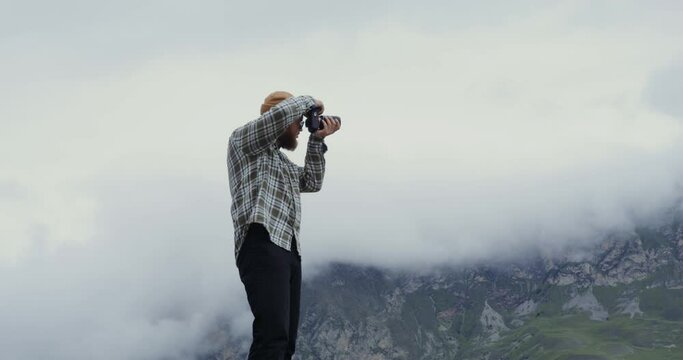 Russia, Caucasus. A man takes pictures of the mountains with a camera