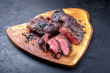 Traditional barbecue wagyu spider beef steak with black salt and spices served as close-up on a rustic wooden board with copy space
