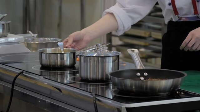 Chef melting butter in pot at cuisine of restaurant. Professional cooking, cookery, gastronomy and healthy food concept