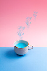 cup of coffee or tea with blue liquid and smoke with z sleep sign. Background in 2 colors, pink and blue. Aesthetic concept of sleep and relaxation.