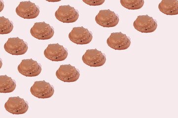 Fototapeta na wymiar Chocolate cookies arranged in a pattern diagonally on a pink background with copy space. Sweet food cookie concept.