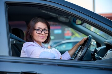 Middle-aged beautiful woman driver driving a car