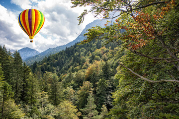 View of high Apls mountains wth a hot air balloon in the blue sky.