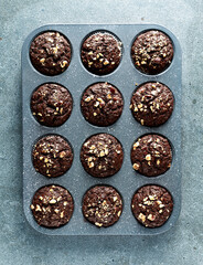 Chocolate muffins with hazelnuts in a baking tray. Top view