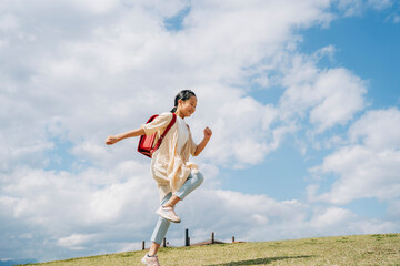 Fototapeta na wymiar 公園で走る小学生の女の子 