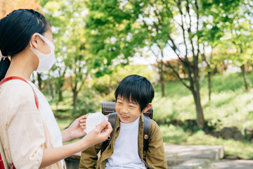 男の子にマスクをつけてあげる女の子
