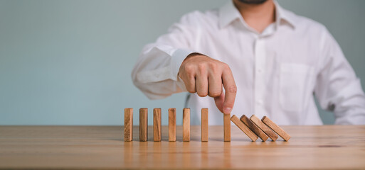 Hand Stopping the domino business crisis effect or risk protection concept, business solution and...
