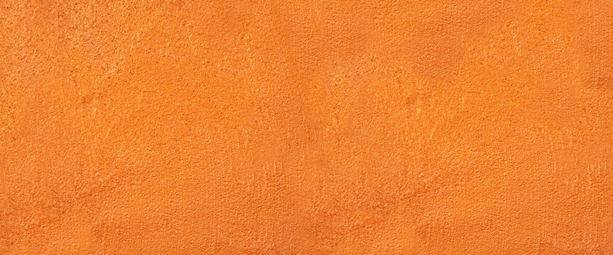 Orange painted rough wall texture or concrete cement background. Texture of a plaster wall for background