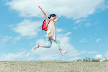 公園で走る小学生の女の子（ジャンプ）
