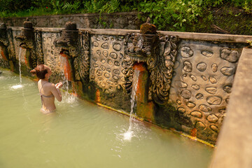 バリ島の秘境で天然温泉に入る女性
