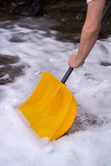 Man with snow shovel cleans backyard or front yard in winter. Winter jobs