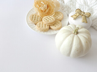 mini pumpkin, cookies on a plate and flowers flat lay scene