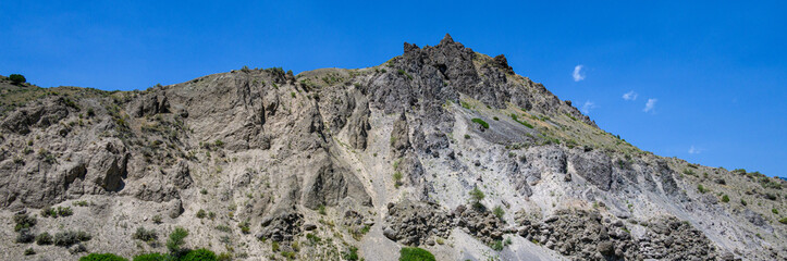 Rocky mountain ridge and peak against a sunny blue sky, Yellowstone National Park, USA
