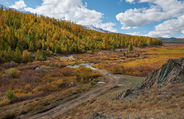 Ford across the river Kurkurek with larch forest and snow mountains are on background.