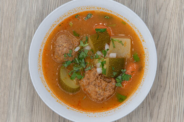 Overhead view of hearty bowl of albondigas meatball soup served hot and spicy