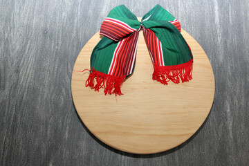 Tricolor party bow: green, white and red. The flag colors of Mexico and Italy for the holidays along with a chopping board as a banner for copy

