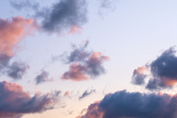 Cloudy day. Many little clouds on orange - blue sky background. Dramatic sky during sunset.