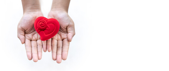 Red heart-shaped box on child's hand, love concept, health care, donate and family insurance concept,world heart day, world health day, concept