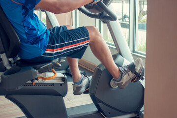 Young man using a spinning bike in an indoor fitness center