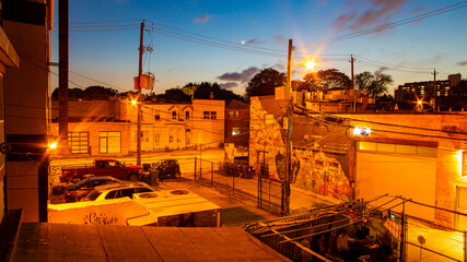 Orange city lights, windows, streets of Toronto under the blue and crimson sunset sky with the crescent moon, Canada. © Karori Production