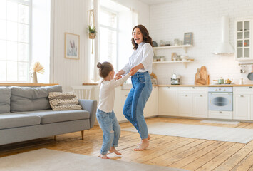 Mom and her daughter are dancing.