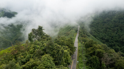 Fototapeta na wymiar Aerial view of countryside road passing through the lush greenery and foliage tropical rain forest mountain landscape in the Northern Thailand, Nan province. Doi phuka