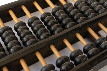 Old Chinese wooden ancient abacus isolated on white background. Calculating and counting number...