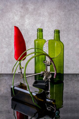 Still life with red pepper, onions and and glass bottles.