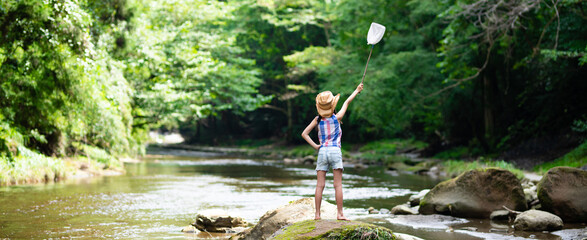 渓流で虫取り網を持つ子供