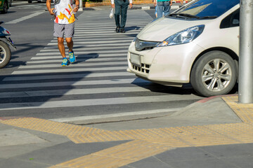 crossing the road on the crosswalk. Vehicles should stop for pedestrians in the crossing.