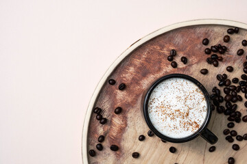 Coffee cup and coffee beans on wooden tray. 