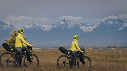 The man and woman travel on mixed terrain cycle touring with bikepacking. The love couple journey...