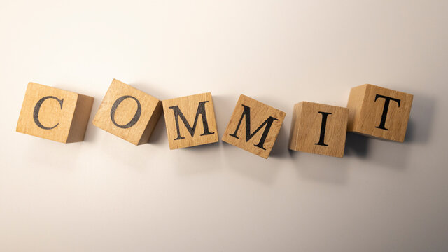 The word Commit was created from wooden cubes.Close-up.