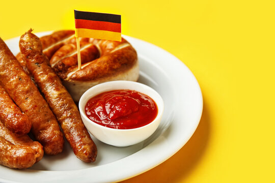 Plate With Tasty Sausages, Sauce And Flag Of Germany On Color Background