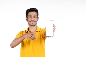 Young indian man showing smartphone on white background