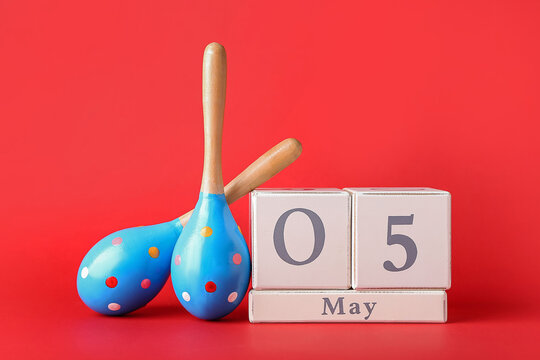 Mexican maracas and calendar with date 5 May (Cinco de Mayo) on color background