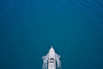 Large white yacht on the water in motion top view. The yacht is fast moving on dark water. Travel...