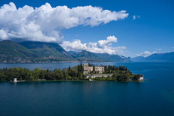 Magnificent aerial panorama of Isola del Garda, Lake Garda, Italy. Castle on an island in Italy. Historic sites on Lake Garda. Isola del Garda, Italy. An island surrounded by the Italian Alps.