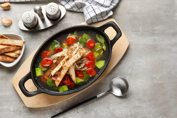 Composition with tasty Sopa de Lima soup on grey background