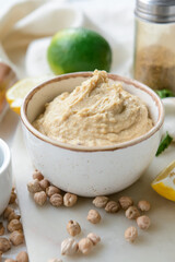 Bowl with tasty hummus and chickpeas on table