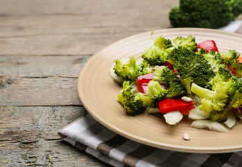 Plate of tasty salad with broccoli on wooden background