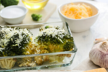 Baking dish with tasty broccoli and cheese on table
