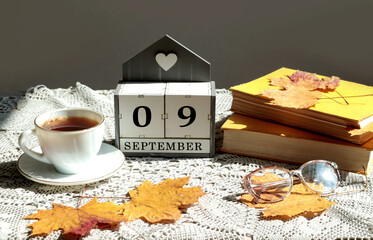 Calendar for September 9 : the name of the month in English, cubes with the numbers 0 and 9, a cup...