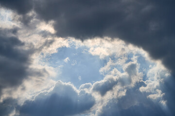 dramatic clouds float across the blue sky
