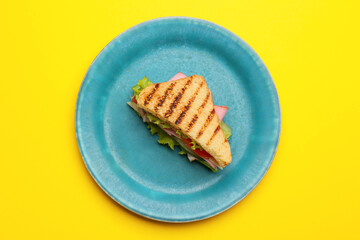 Plate with tasty sandwich on color background