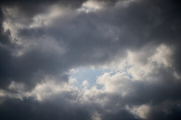 dramatic clouds float across the blue sky