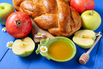 Honey with fruits and challah on color wooden background. Rosh hashanah (Jewish New Year) celebration