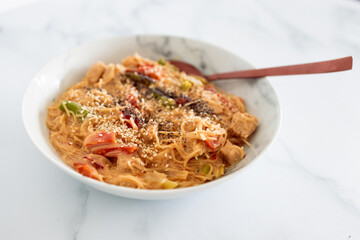 vegan asian satay veggies with vermicelli noodles and sesame and poppy seeds topping, healthy plant-based food