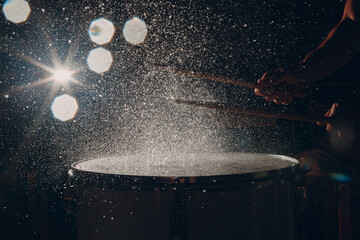 Close up drum sticks drumming hit beat rhythm on drum surface with splash water drops