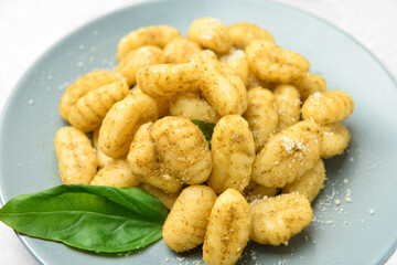Plate with tasty pesto gnocchi on table, closeup